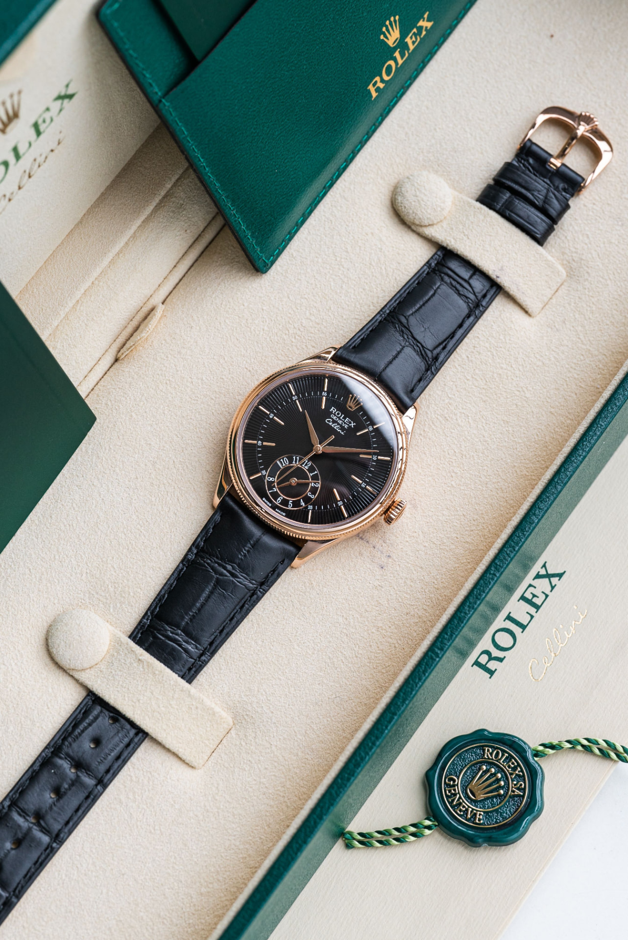 Rose-gold Rolex Cellini with black dial and strap, presented in its green Rolex box